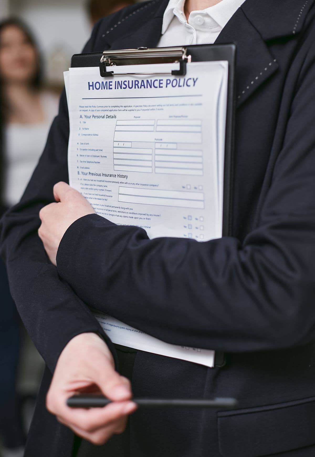 Person holding a home insurance policy on a clipboard