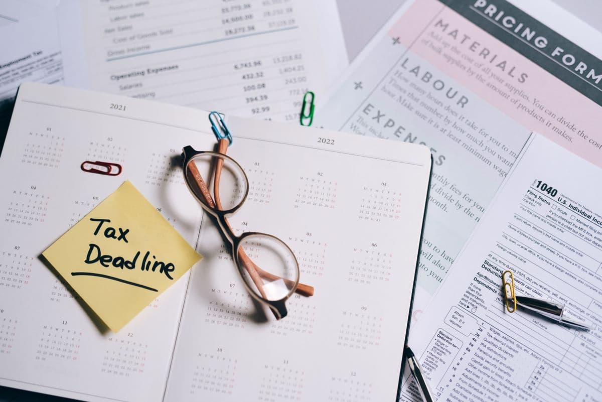 Calendar marked with a tax deadline surrounded by financial documents
