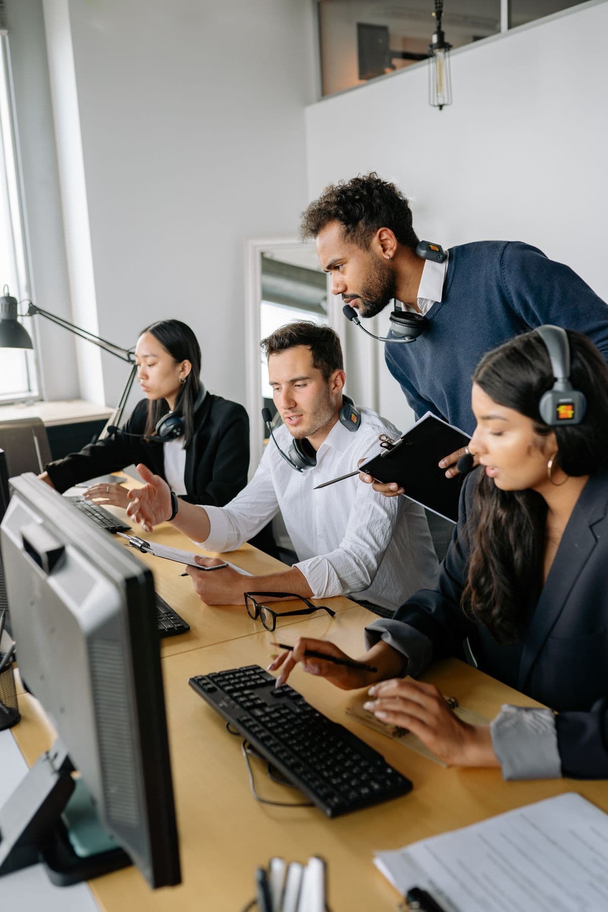 Diverse group of insurance staff collaborating at desks with headsets