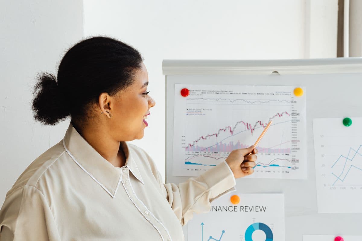 Woman pointing at a stock market chart explaining financial trends